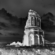 L'église Saint-Sauveur s'élance vers le ciel, traçant une verticale dans ce paysage lunaire d'Ani, capitale du royaume d'Arménie. Datant du XIème siècle, cette église fut construite à la demande du prince Ablgharid Pahlavide, afin d'y déposer une relique de la «vraie croix» ramenée de Constantinople. Son plan circulaire composé de douze colonnes sur sa façade extérieure, en fait un bâtiment unique. 